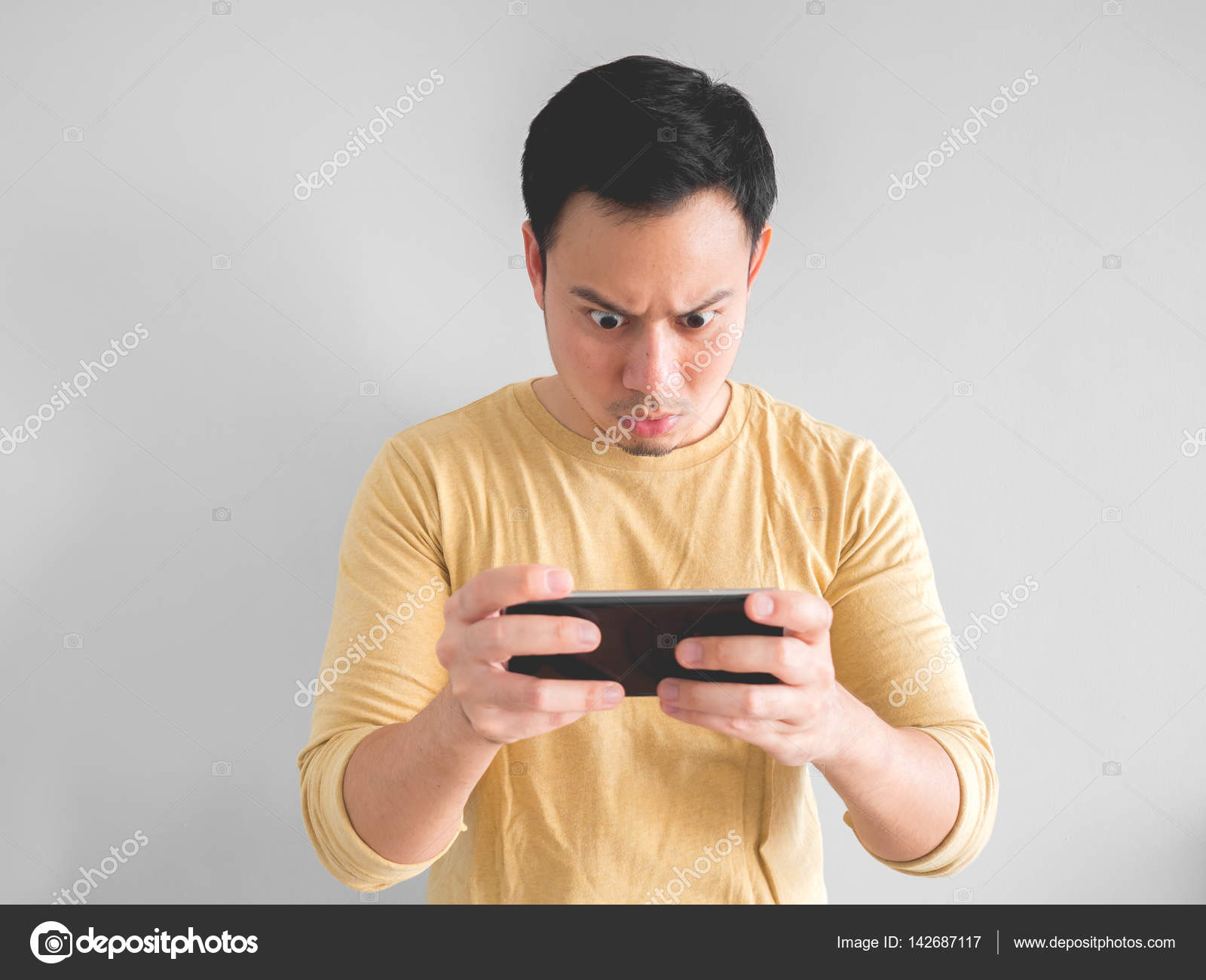 Asian Man Playing Mobile Game Seriously Stock Photo by ©sevendeman